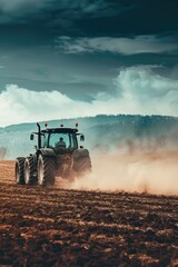 Fototapeta premium Agricultural machine tilling soil under overcast sky