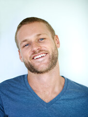 Obraz premium Laughing, portrait and man in studio with casual fashion, confidence and creative career in design. Smile, face and young professional with cool pride, gen z style and happy fun on white background