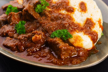 Beef goulash and dumplings (knedliky) on table