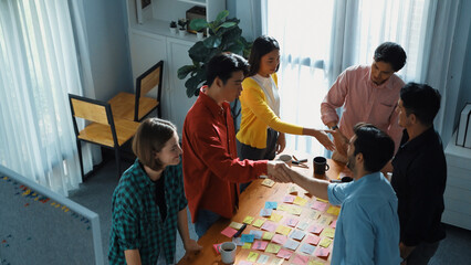 Top view of smart business team writing marketing idea on colorful sticky notes while start up team working together and brainstorming plan at meeting table in boardroom. Creative concept.Convocation.