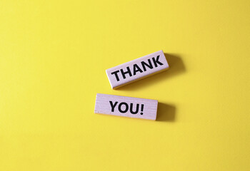 Thank you symbol. Wooden blocks with words Thank you. Beautiful yellow background. Business and Thank you concept. Copy space.