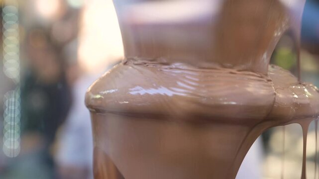 big  fondue with chocolate. chocolate is pouring out like a fountain