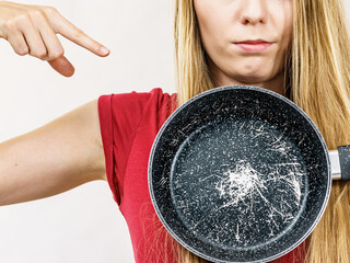 Girl holding scratched frying pan