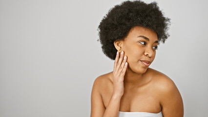 An elegant african american woman with curly hair poses against a white background, radiating beauty and serenity.