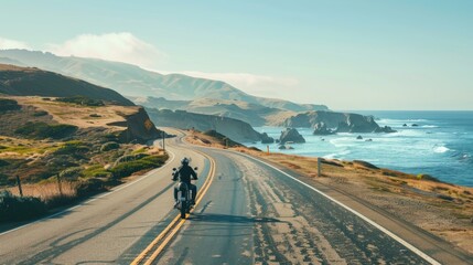 Fototapeta premium A person riding a motorcycle along a scenic coastal road, with the ocean in the background