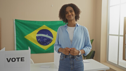 A beautiful young african american woman with curly hair stands in an indoor electoral college room...