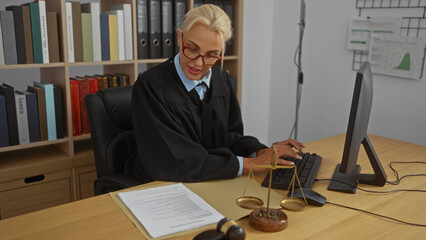 Woman working in office as judge, typing on computer with documents and justice scales on desk