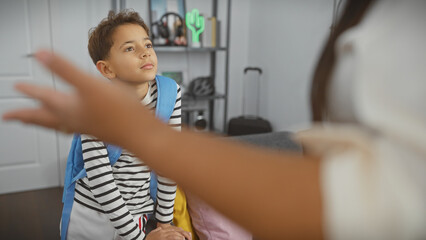 Boy listens to woman speaking in a modern living room, indicating family communication in a home setting.