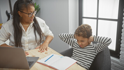 Obraz premium A woman helps a frustrated boy with homework in a modern living room