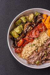 Bowl of food with beef, bulgur, tomatoes, mushrooms, zucchini