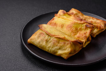 Homemade fried pancakes with filling on a ceramic plate