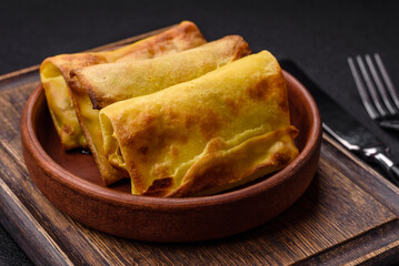 Homemade fried pancakes with filling on a ceramic plate