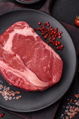 Fresh, raw beef steak with salt, spices and herbs