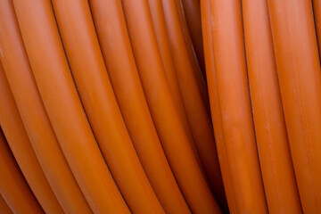 close-up of several bright orange PVC pipes stacked together Picture.