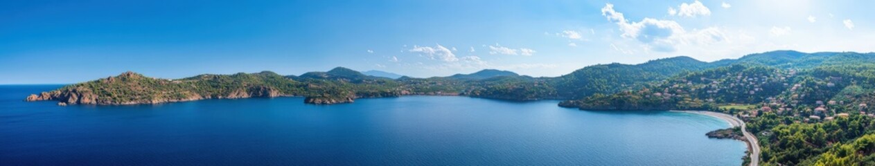 Obraz premium Serene coastal landscape with blue water and lush hills in afternoon light