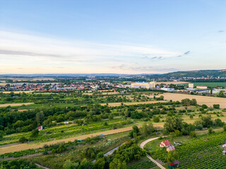 A stunning drone view of Hrusovany u Brna, showcasing the charming town, surrounding vineyards, and a distant, scenic view of the Palava Hills.