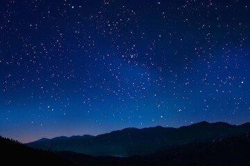 A starry night sky with mountains in the background
