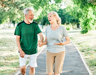 Fototapeta premium outdoor senior fitness woman man lifestyle active sport exercise healthy fit couple running jogging elderly mature having fun laughing talking together friend hug break