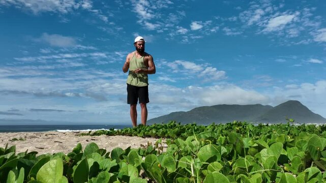 Man on a sunny day at the beach having a picnic, eating and drinking water. Outdoor concept.