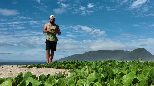 Man on a sunny day at the beach having a picnic, eating and drinking water. Outdoor concept.