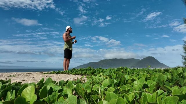 Man on a sunny day at the beach having a picnic, eating and drinking water. Outdoor concept.