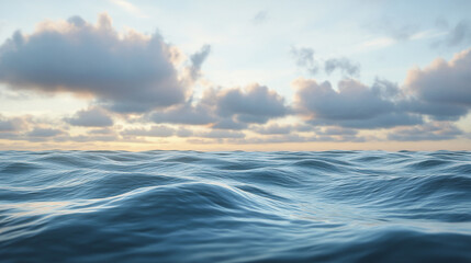 Obraz premium Calm ocean waves roll gently beneath a cloudy sky, offering a serene seascape.