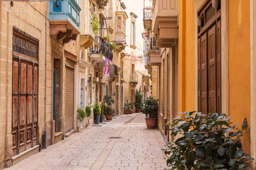 Obraz premium Malta, Birgu. Narrow street with stone buildings.