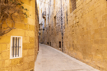 Malta, Mdina. Narrow street between two stone buildings.