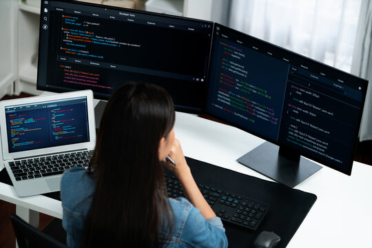 Top view young Asian IT developer creating with typing online information on pc with coding program data of website application, wearing jeans shirt. surround by safety analysis two screen. Stratagem.