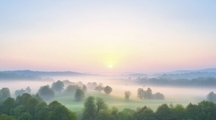 Fototapeta premium The soft glow of dawn emerging over a foggy terrain, stirring the world with delicate shades of light and warmth.