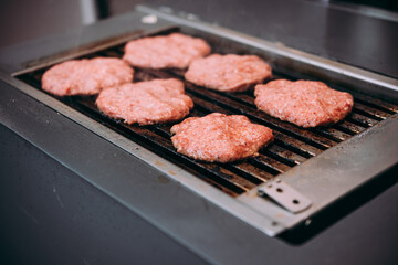 Grilling meat patties for classic burger in a cafe of a restaurant.