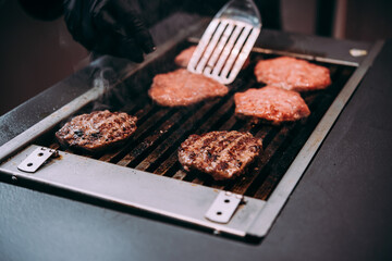 Grilling meat patties for classic burger in a cafe of a restaurant.