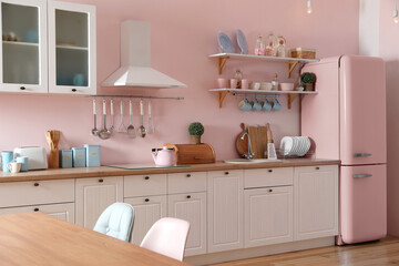 Pink refrigerator in furnished kitchen. Stylish interior