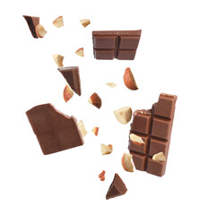 Pieces of tasty chocolate and hazelnuts in air on white background