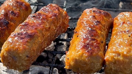 Inegöl or Tekirdag Meatballs a type of grilled meat dish famous in Turkey made from minced lamb or beef Outdoor Close up. Man fries patties on barbecue. Meatballs on grill. Spicy minced meat rolls BBQ