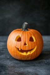 Fototapeta premium Happy Halloween pumpkin with carved face on dark background