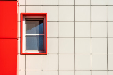 Vibrant red window contrasts with modern white facade in urban setting