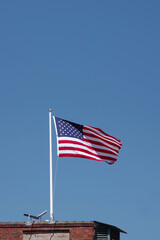 Fototapeta premium United States of America Flag waving under blue sky