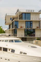 Luxury yacht by a mansion house in background