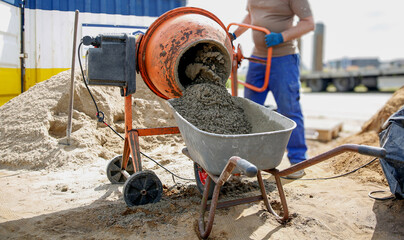 Constriction worker making concrete in an orange mixer