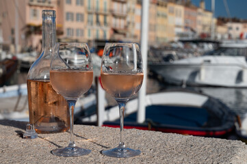 Glasses of cold rose Cote de Provence wine in old fisherman boats and yacht harbour in Saint-Tropez, summer vacation on French Riviera in Provence, France