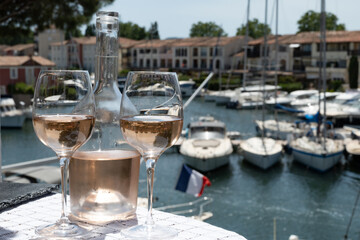 Glasses of cold rose gris Cote de Provence wine in yacht harbour of Port Grimaud, summer vacation on French Riviera in Provence, France
