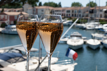 Summer party, French brut rose champagne sparkling wine in flute glasses in yacht harbour of Port Grimaud near Saint-Tropez, French Riviera vacation, Var, France