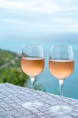 Summer time in Provence, two glasses of cold rose wine with blue sea view on background, French Riviera near Menton, south of France