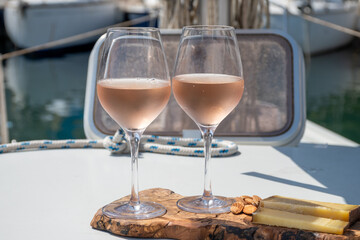 Party with rose wine on yacht boat anchored in port la Rague, Gulf of La Napoule, in Provence, two glasses of cold rose wine, French Riviera near Cannes, south of France