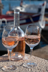 Glasses of cold rose Cote de Provence wine in old fisherman boats and yacht harbour in Saint-Tropez, summer vacation on French Riviera in Provence, France