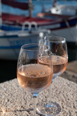 Glasses of cold rose Cote de Provence wine in old fisherman boats and yacht harbour in Saint-Tropez, summer vacation on French Riviera in Provence, France
