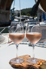 Party with rose wine on yacht boat anchored in port la Rague, Gulf of La Napoule, in Provence, two glasses of cold rose wine, French Riviera near Cannes, south of France