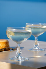 Cold sparkling wine, cava or champagne in two coupe glasses on table with blue sea water view, French Riviera is summer, France