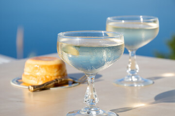 Cold sparkling wine, cava or champagne in two coupe glasses on table with blue sea water view, French Riviera is summer, France